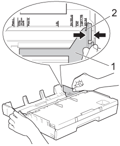 Press and slide the paper side guides to fit the paper size